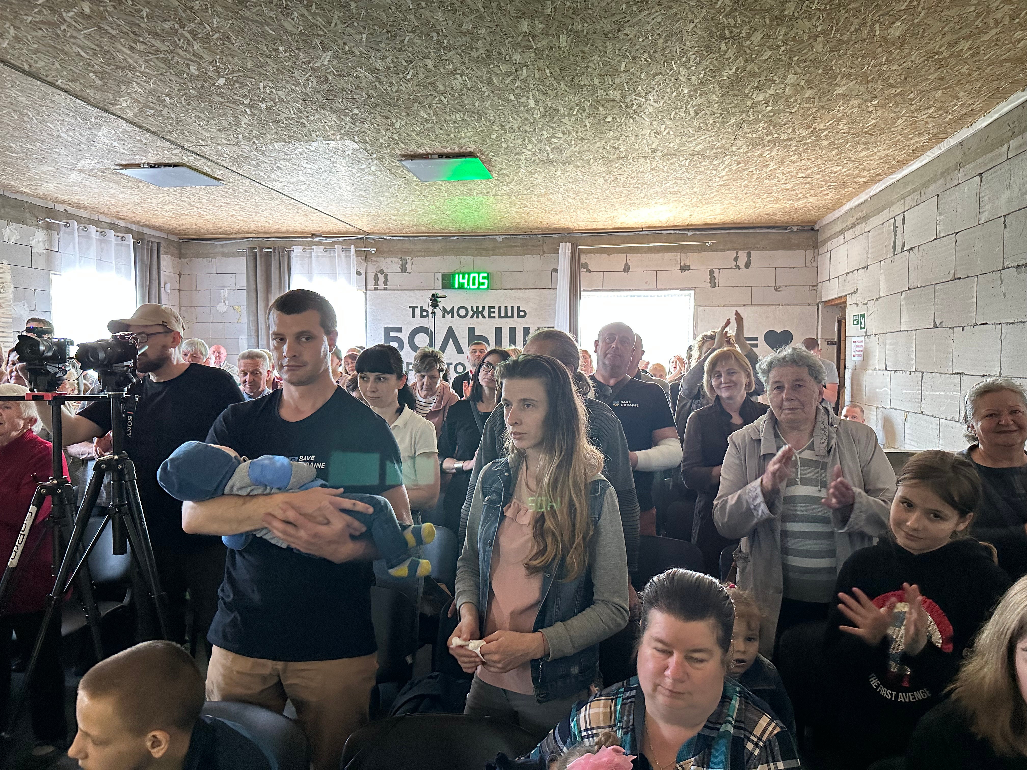TBN UA - A crowd of people and a man holding a baby