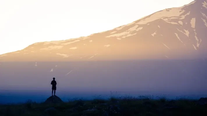 A person walking in the shadows while reflecting on their life
