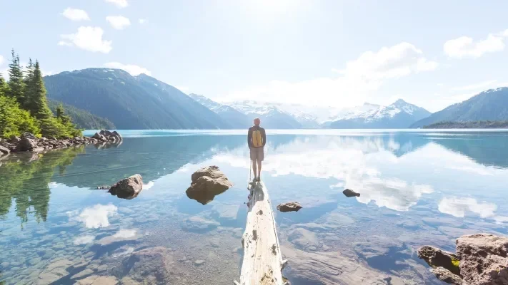 A person reflects on spiritual healing and wellness at a lake